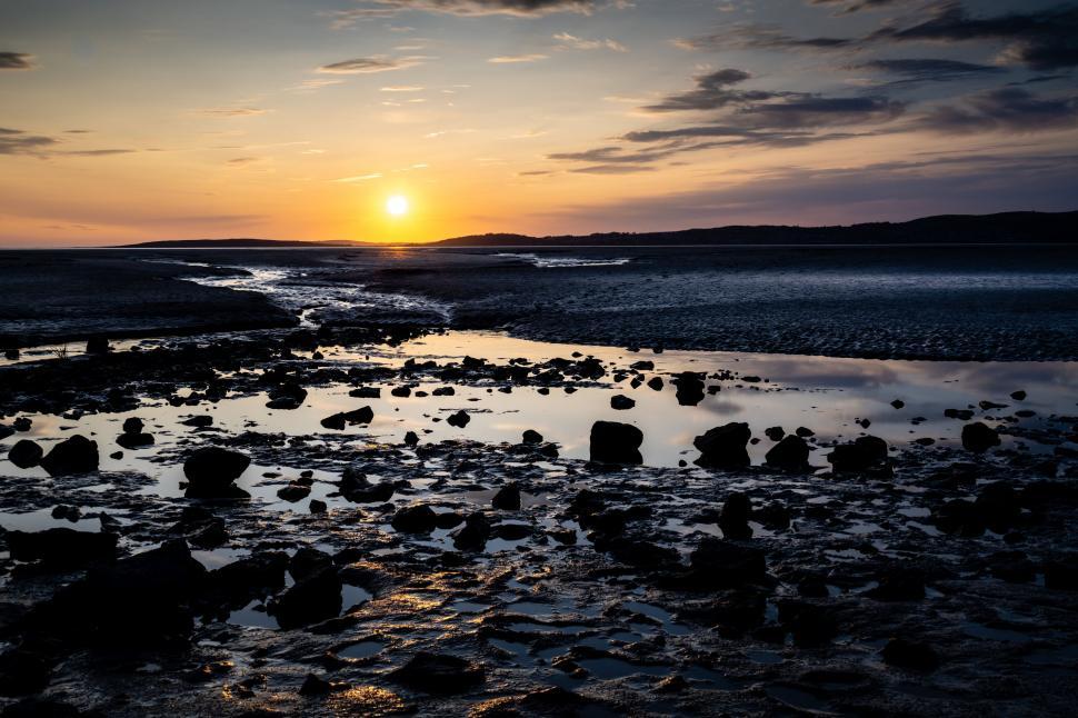 Free Image of Sunset over a coastal rocky landscape 