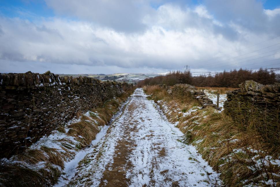 Free Image of Snow-covered path with stone walls 