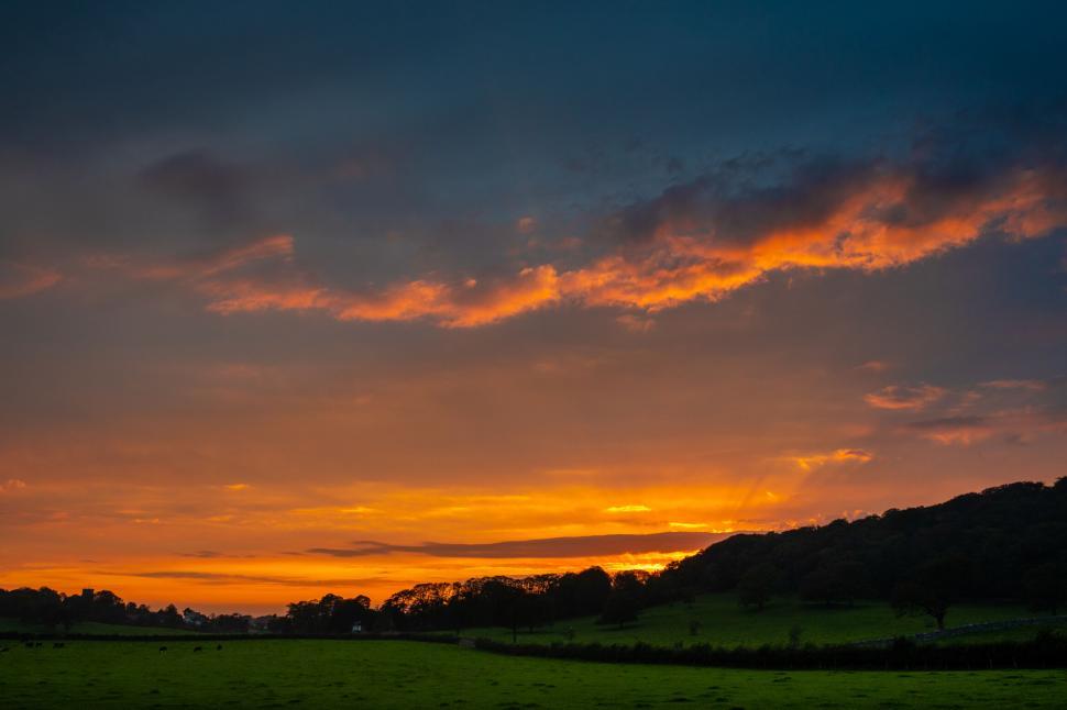 Free Image of Fiery sunset over peaceful countryside 