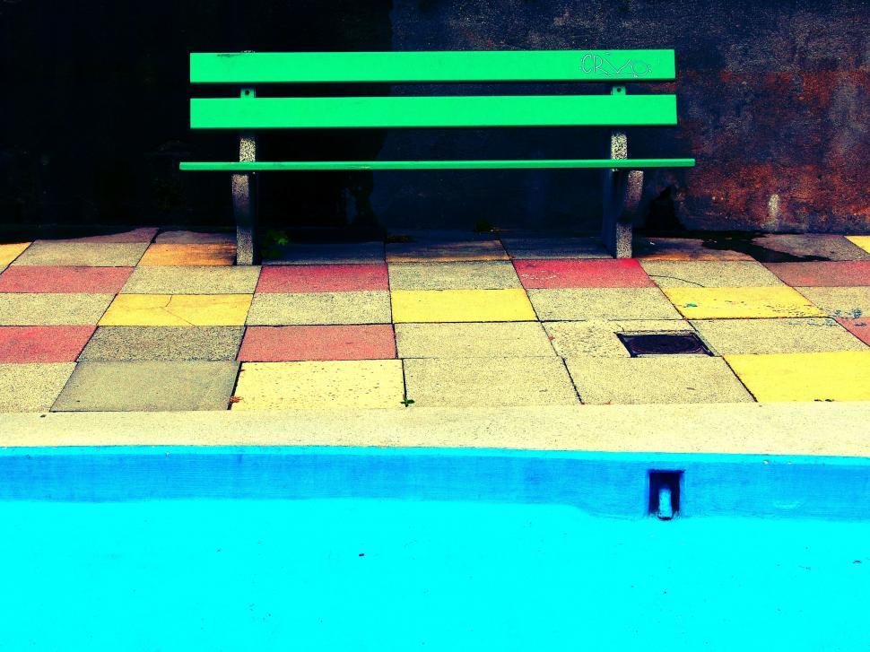Free Image of Vibrant bench on multicolored pavement by pool 