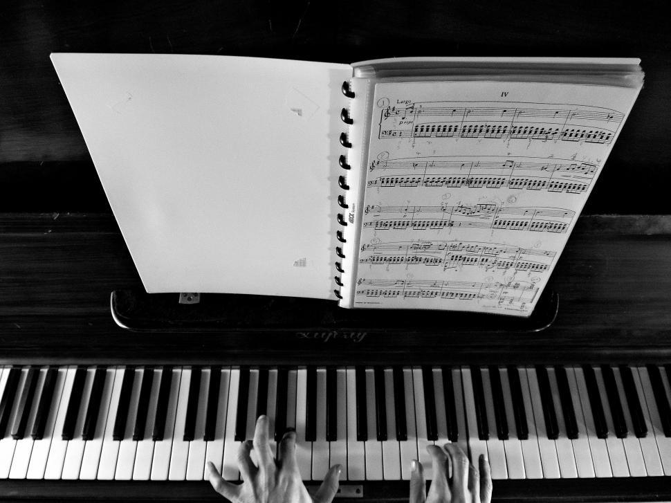 Free Image of Piano with hands and sheet music 