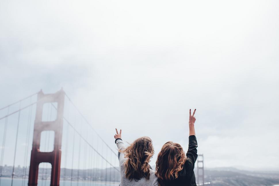 Free Image of Friends celebrate in front of Golden Gate Bridge 