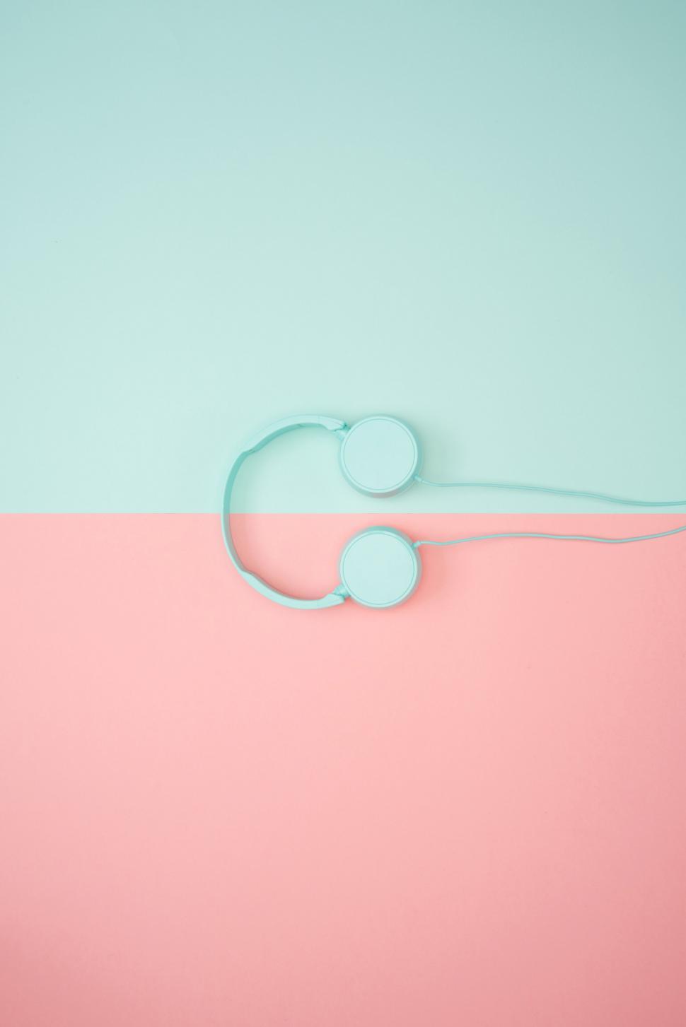 Free Image of Turquoise headphones on a pink and blue background 
