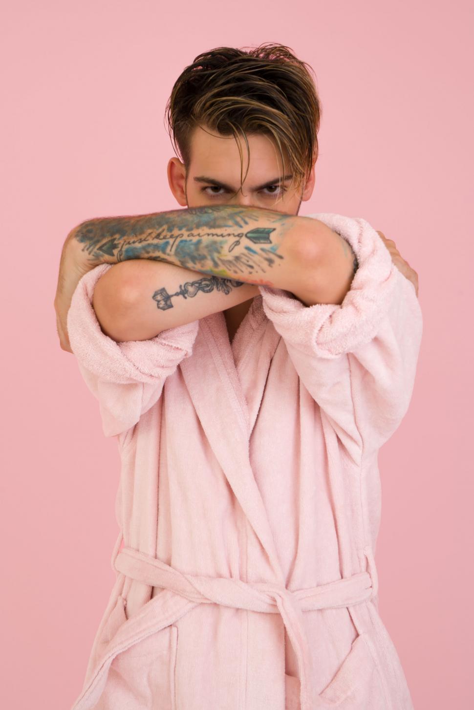 Free Image of Person in pink bathrobe with arms crossed and face hidden 