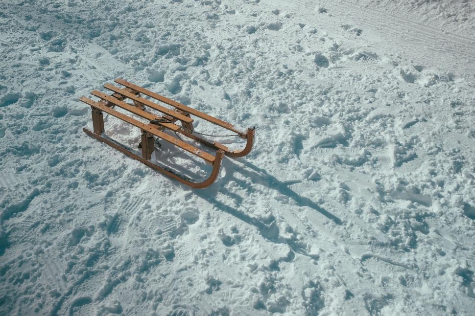 Free Image of Wooden sled left on textured snow 