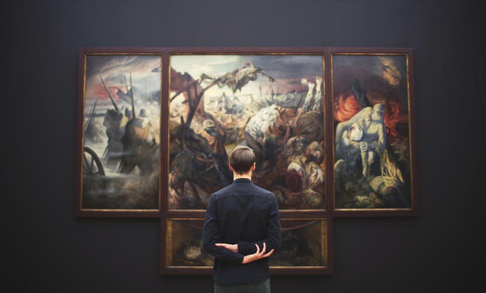 Free Image of Person admiring a large triptych painting 