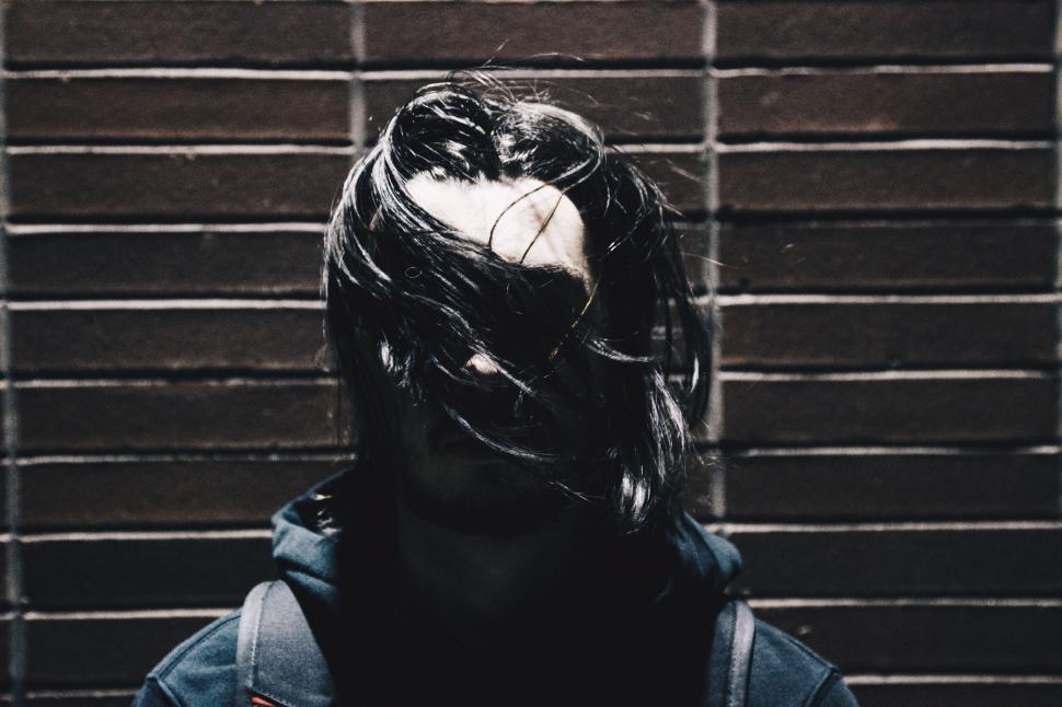 Free Image of Face obscured by a wig in dark alley 