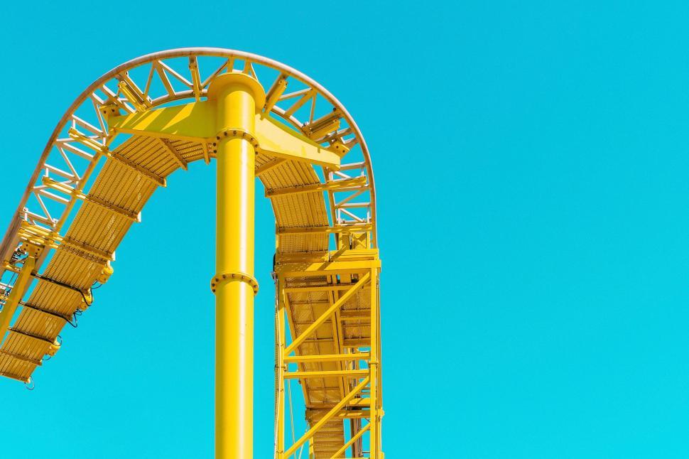 Free Image of Yellow roller coaster track against blue sky 