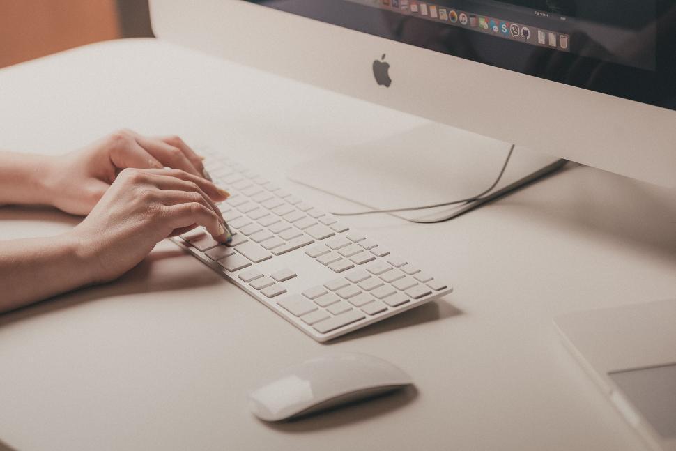Free Image of Person working on an Apple iMac computer 