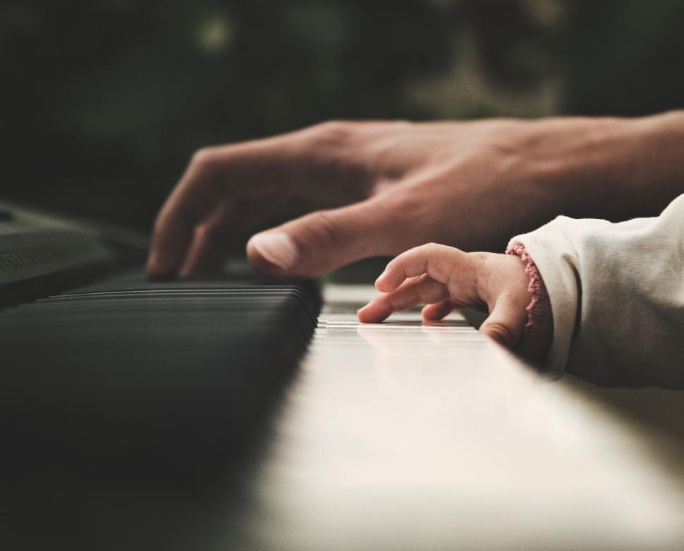 Free Image of Adult and child hands on piano keys 