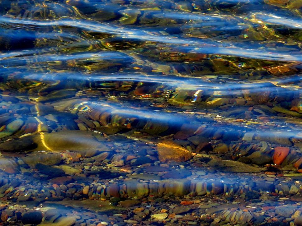 Free Image of Rippling water over smooth river pebbles 