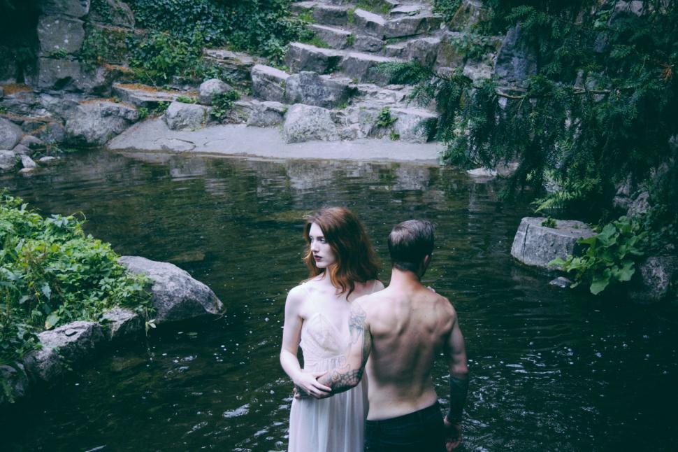 Free Image of Couple standing in a stream serene scene 