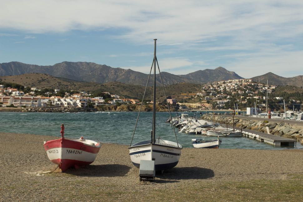 Free Image of Boats on a beach with a seaside town 
