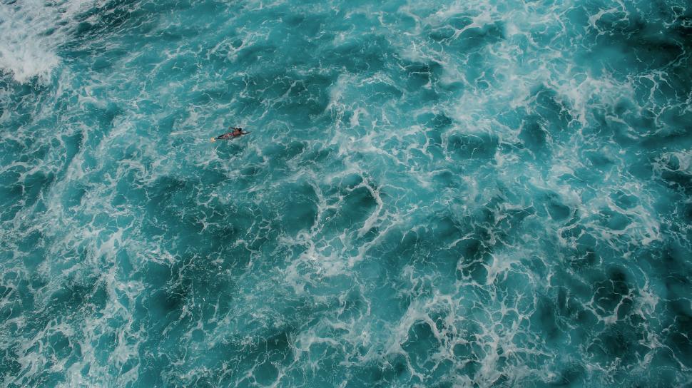 Free Image of Surfer amidst rough turquoise ocean waves 