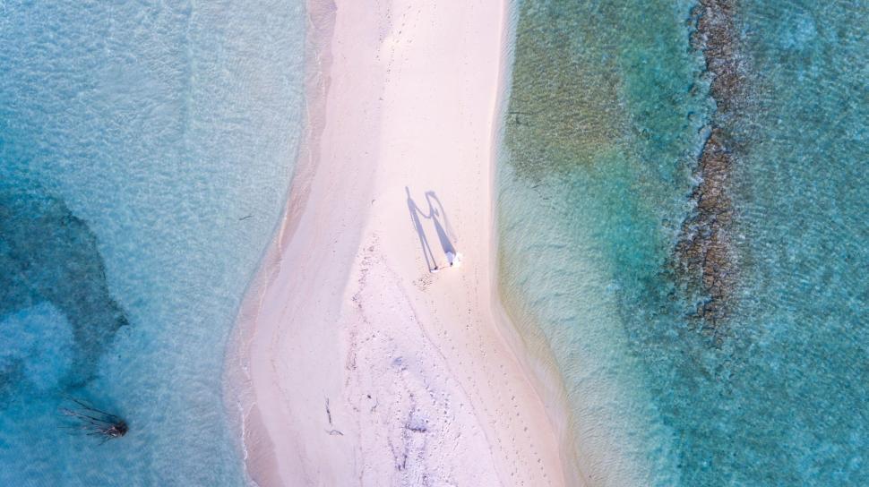 Free Image of Aerial view of couple on a sandy spit 
