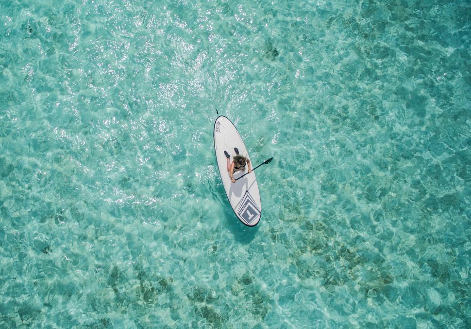 Free Image of Solo paddler on serene tropical waters 