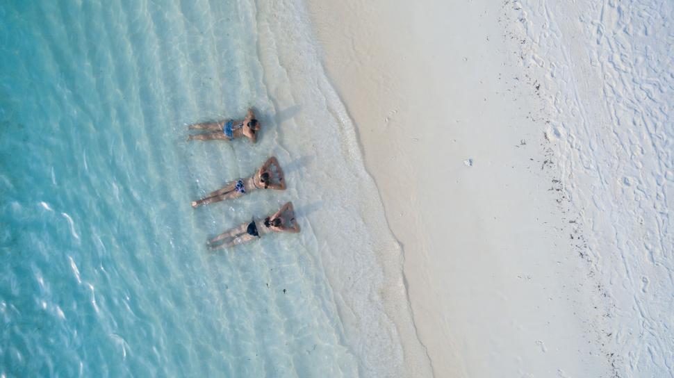 Free Image of People floating in clear shallow water 