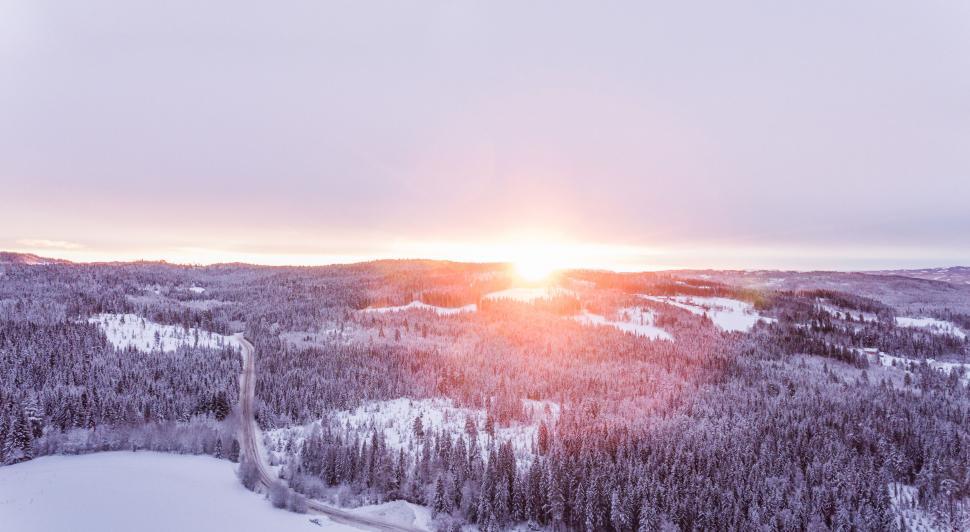 Free Image of Sunrise over a snowy mountain forest 