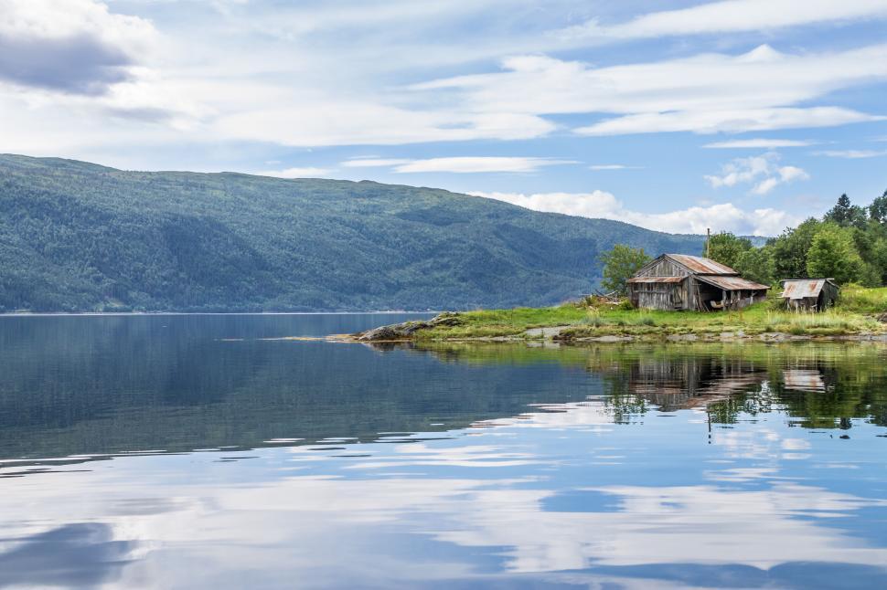 Free Image of Old cabin on a serene lakeside 