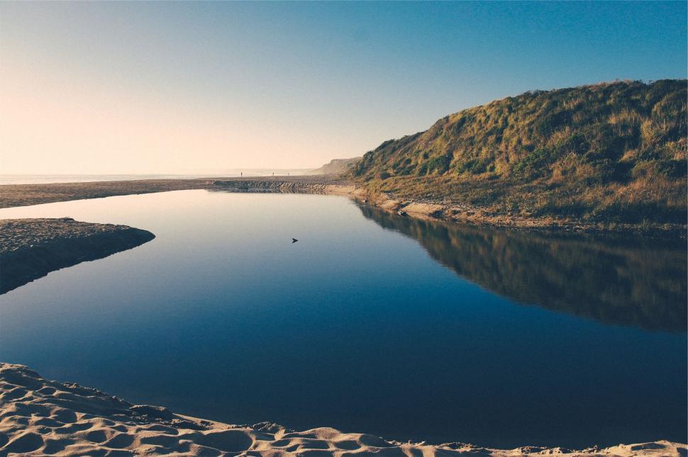Free Image of Tranquil river next to sandy beach 