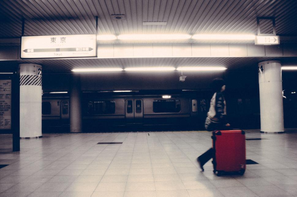 Free Image of Traveler at a train station with suitcase 