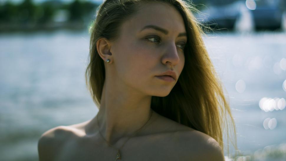 Free Image of Woman with sun-kissed profile by the water 