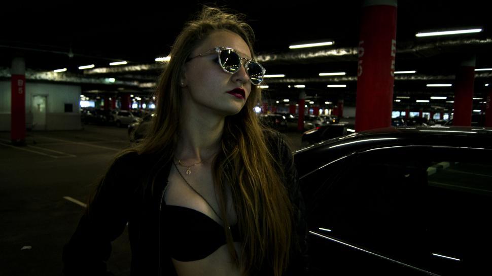 Free Image of Woman by car in parking garage 