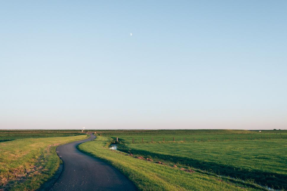 Free Image of Winding country road under evening sky with moon 