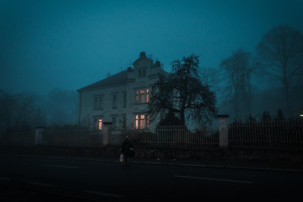 Free Image of Misty evening scene with lit mansion 