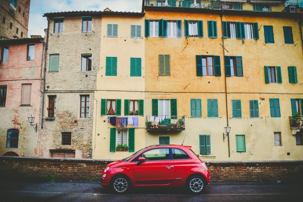 Free Image of Colorful Italian street with red car 