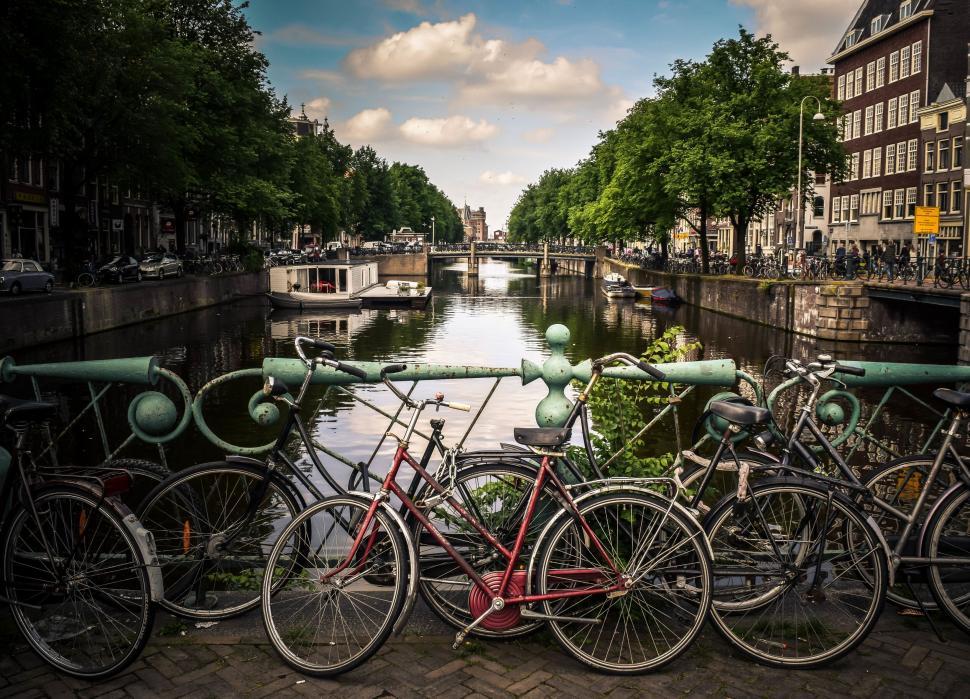 Free Image of Bicycles parked along city canal 
