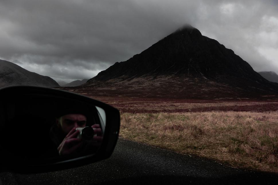 Free Image of Car rear view mirror with mountain landscape 