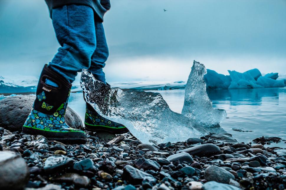 Free Image of Child exploring icy shore in vibrant boots 