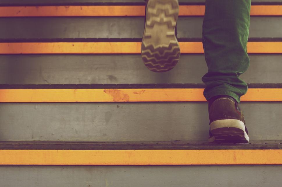 Free Image of Person stepping up orange-lined stairs 