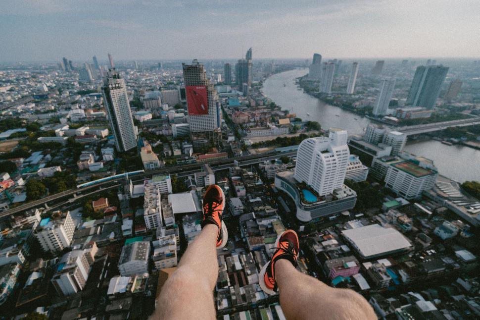 Free Image of Person dangling feet over cityscape 