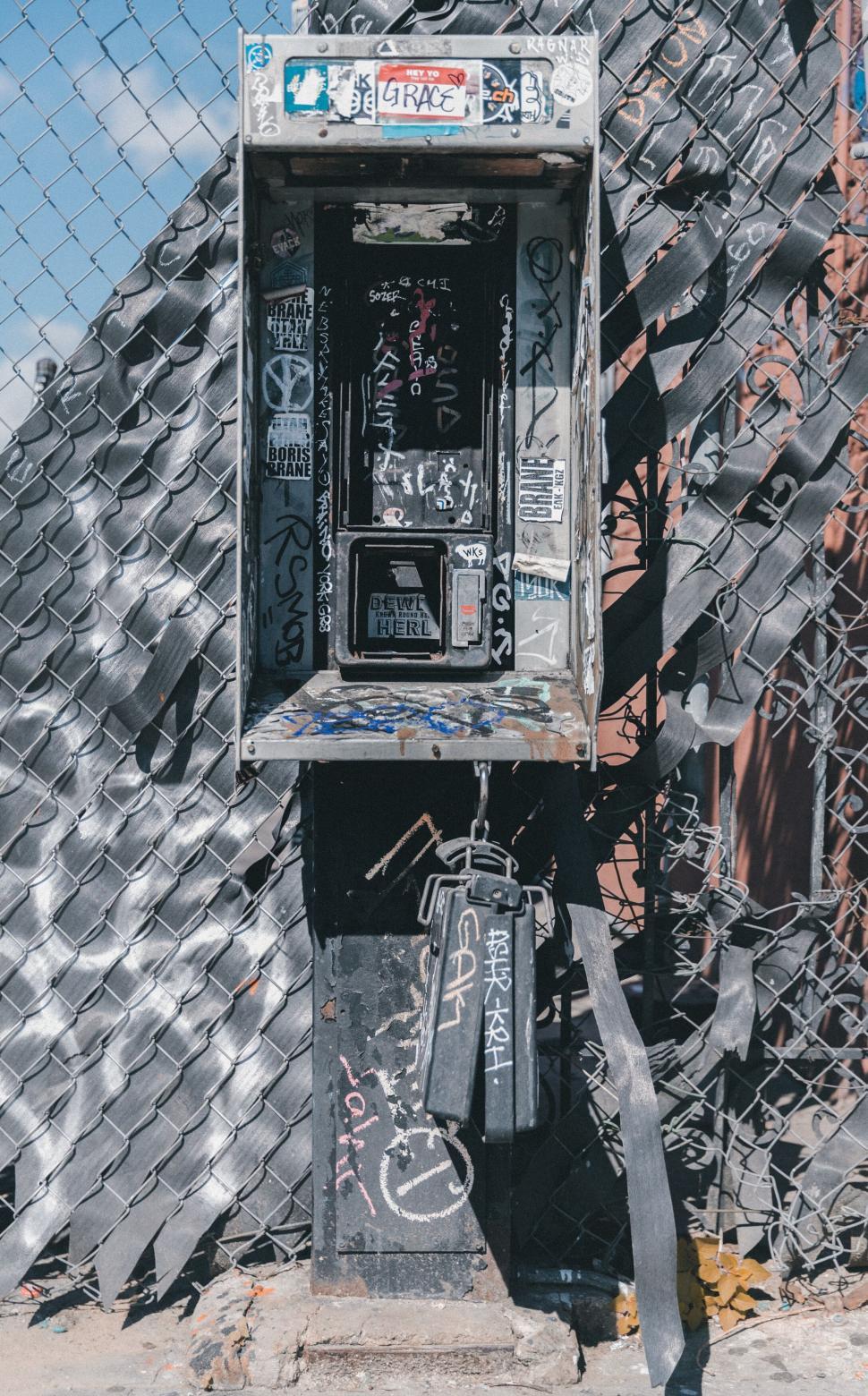 Free Image of Graffiti-covered payphone and fire extinguisher 