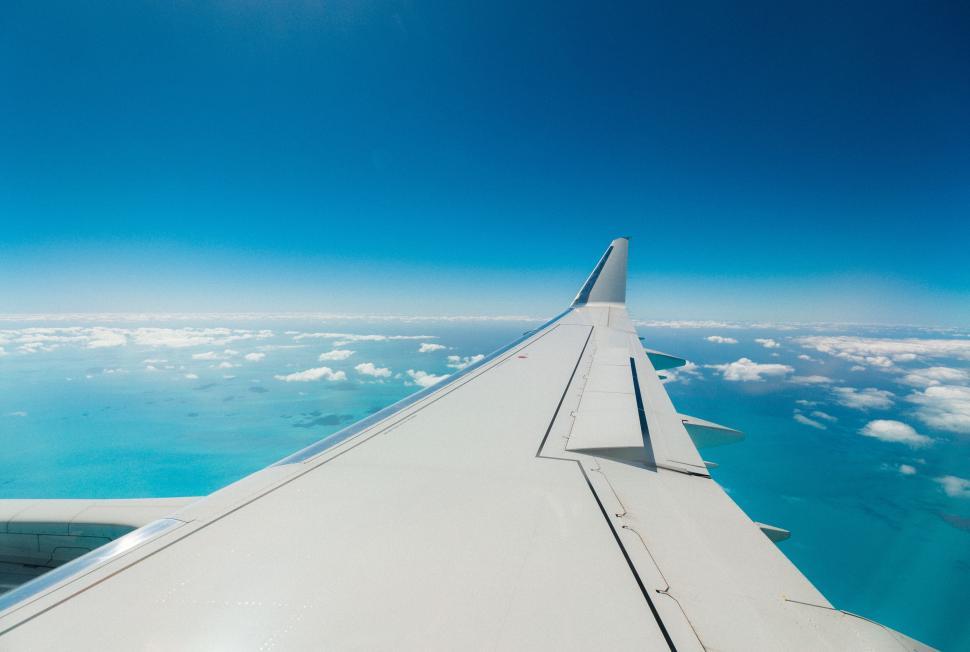 Free Image of Airplane wing over a cloud-covered ocean 
