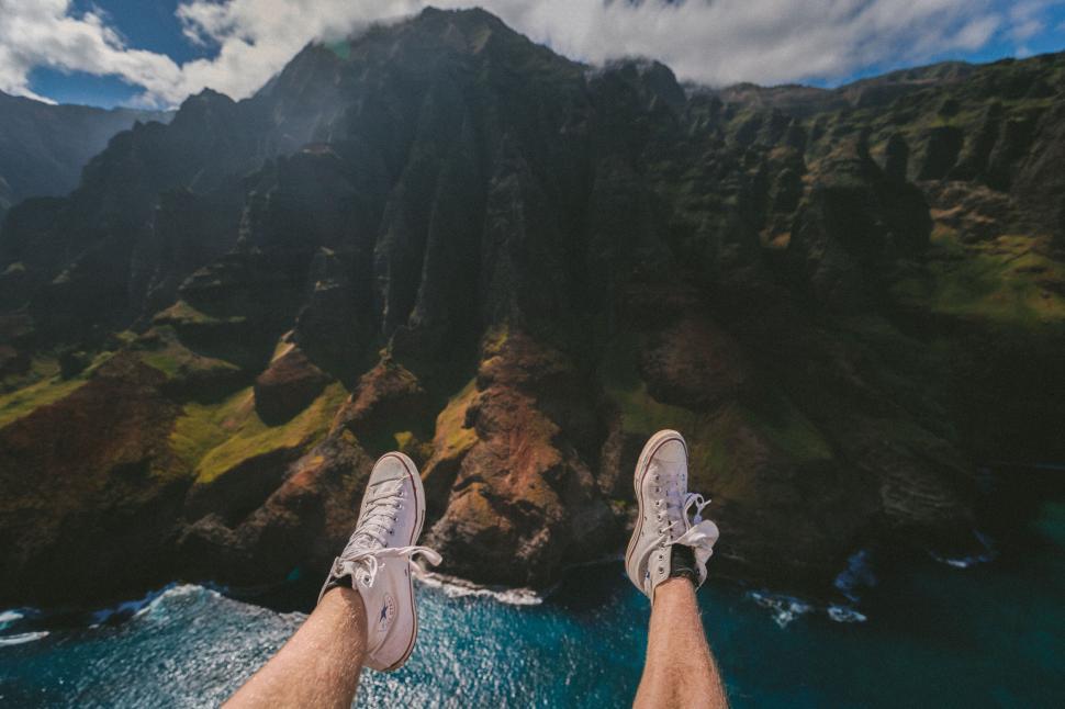 Free Image of Legs dangling over a scenic cliff view 