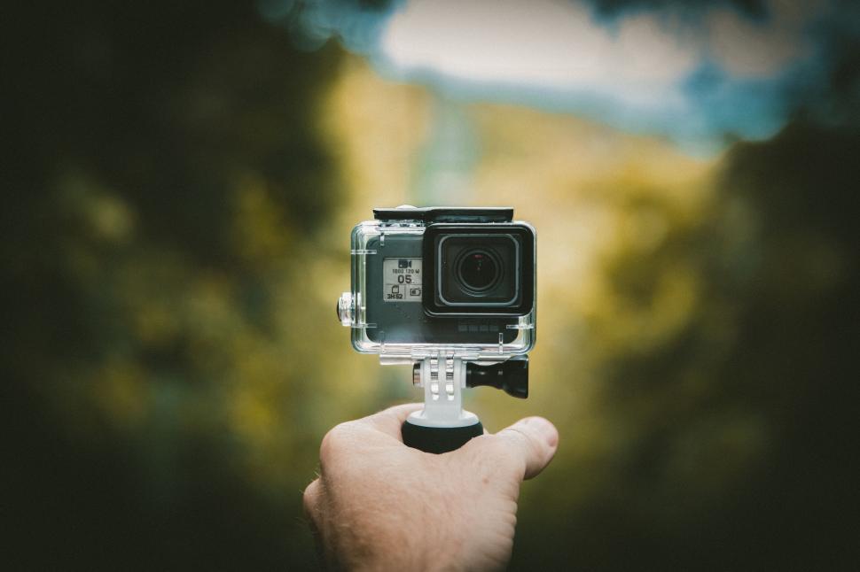 Free Image of Hand holding a GoPro camera against blur 