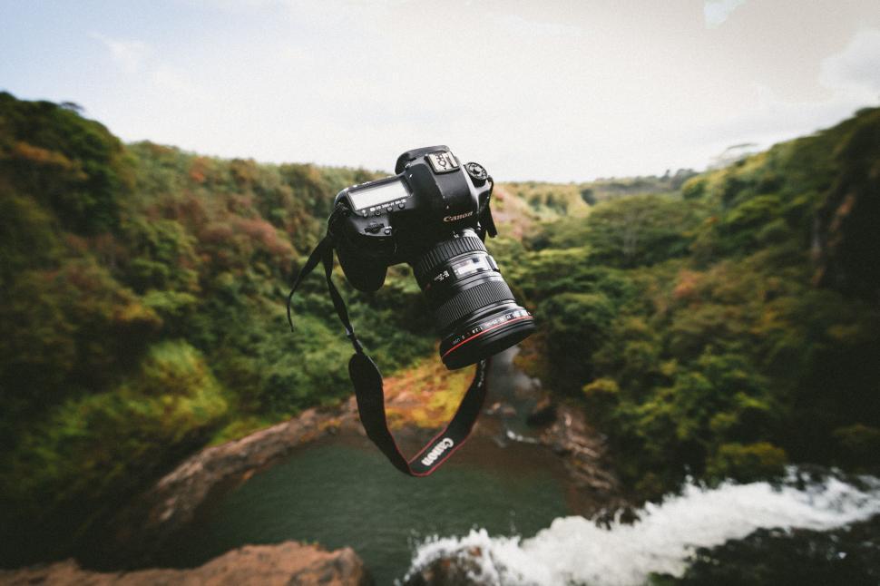 Free Image of DSLR camera hanging above a luscious forest 