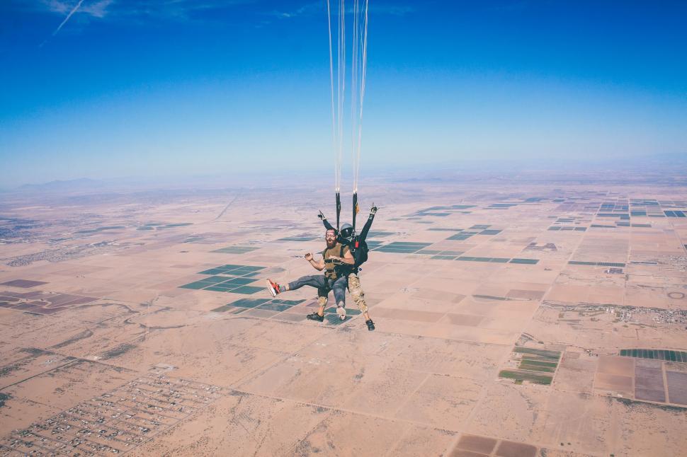 Free Image of Skydivers in mid-air against landscape 