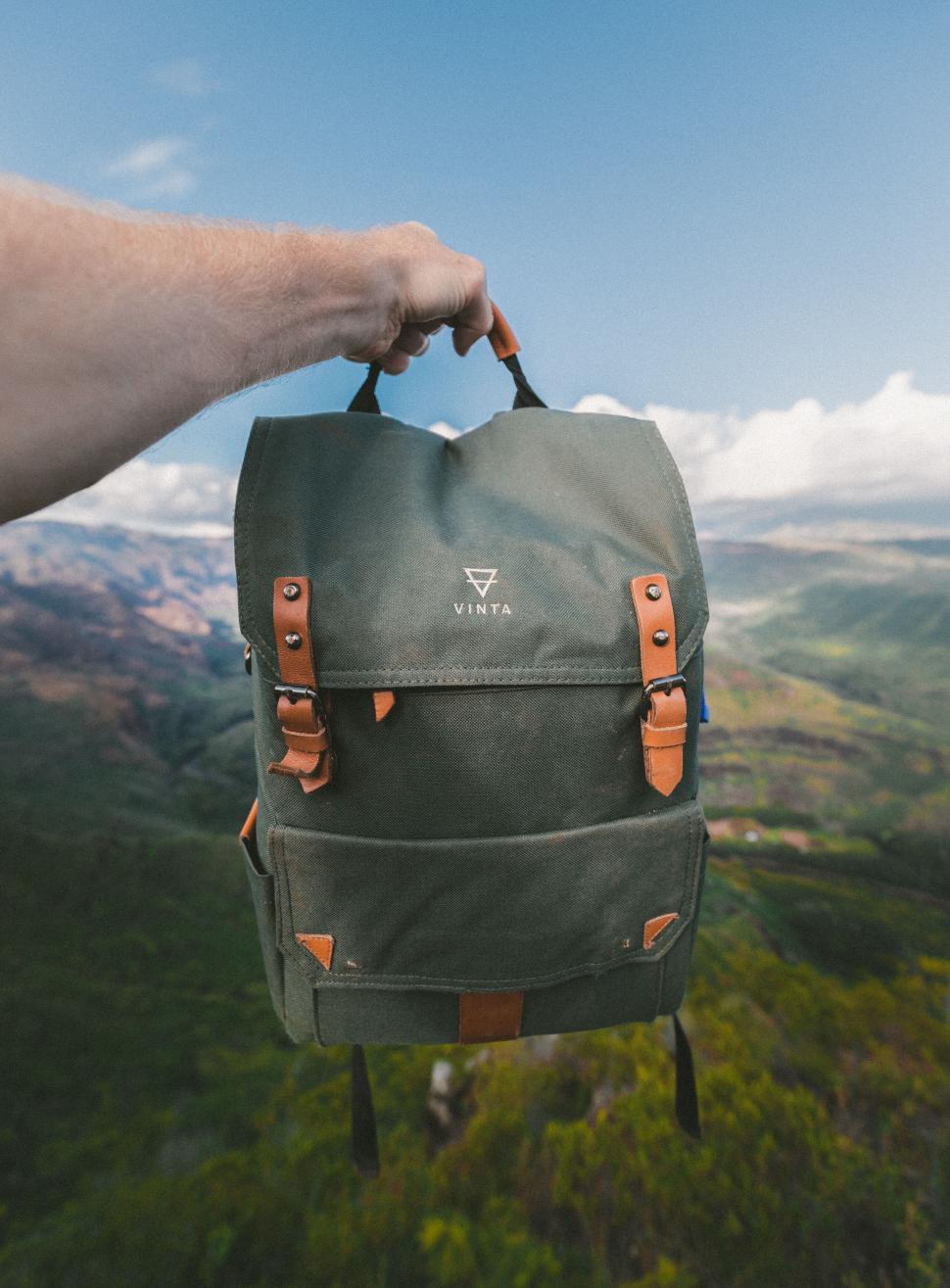 Free Image of Backpack held up against scenic nature 