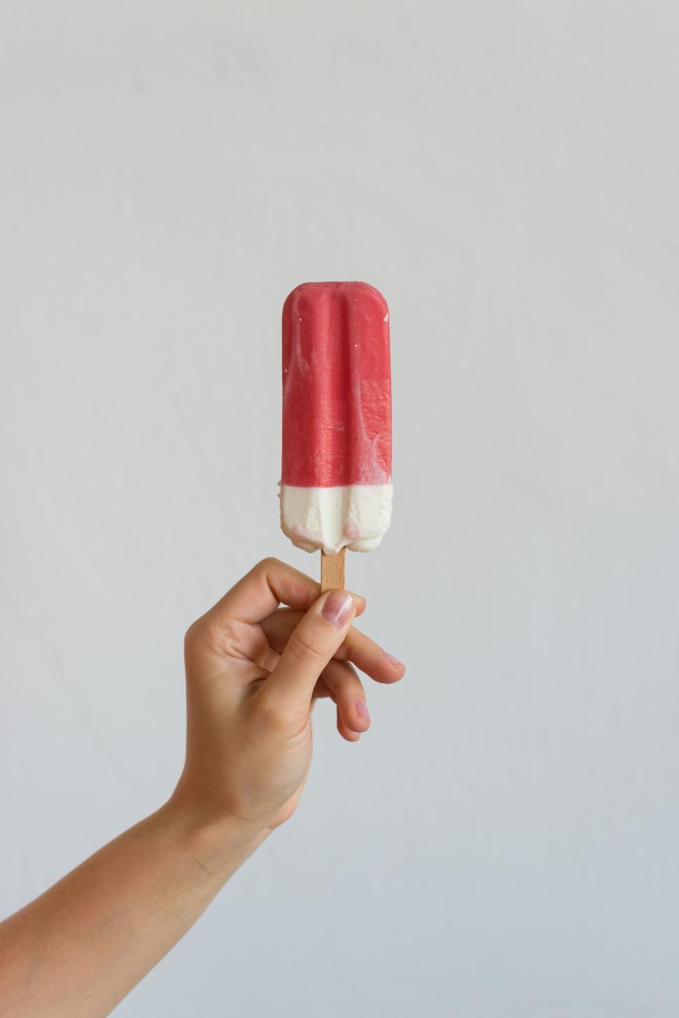 Free Image of Hand holding a red and white popsicle 