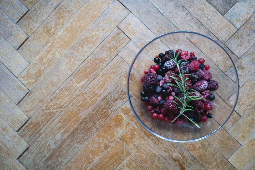 Free Image of Bowl of mixed berries on wooden floor 