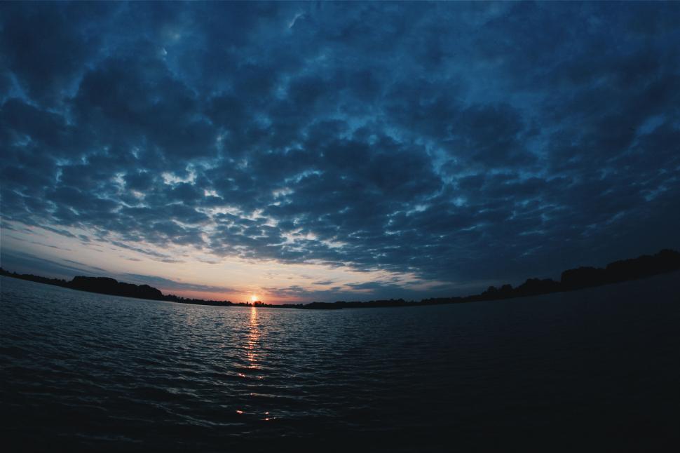 Free Image of Sunset over water with dramatic sky 