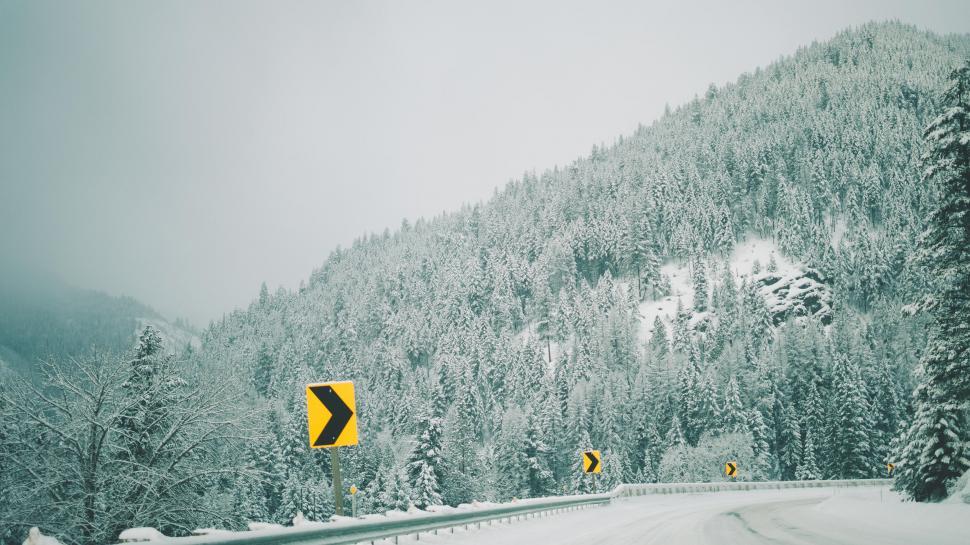 Free Image of Snowy mountain road with yellow warning signs 