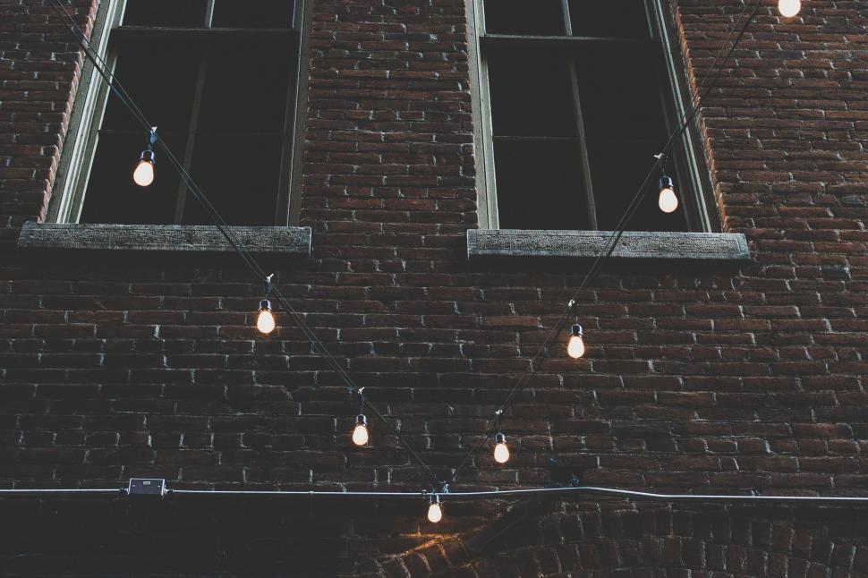 Free Image of String lights against a brick wall 