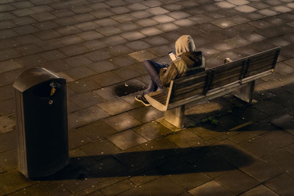 Free Image of Person sitting alone on bench at night 