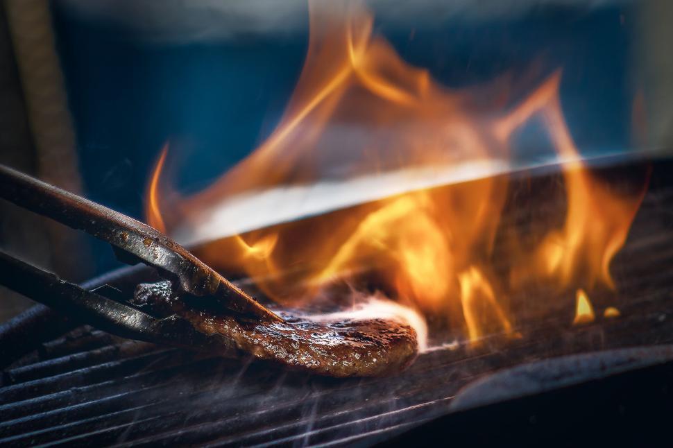 Free Image of Grilling sausage over flaming barbecue 