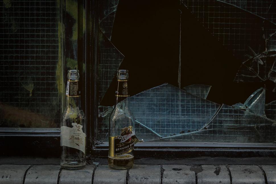 Free Image of Empty beer bottles and broken window 